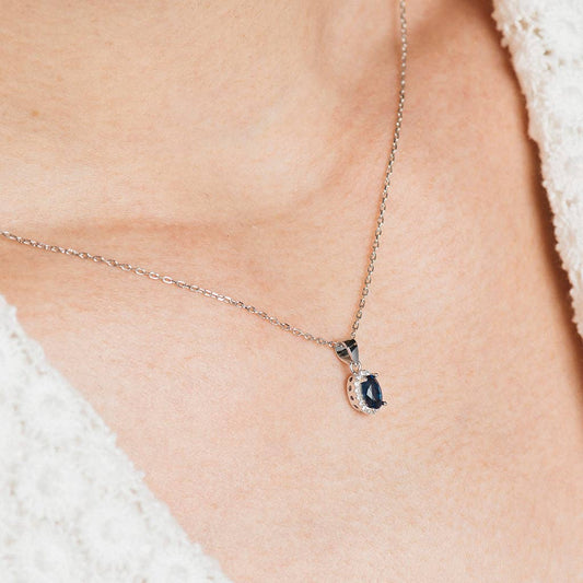 Ovale halsketting en oorbellen bezet met witte en blauwe zirkonen